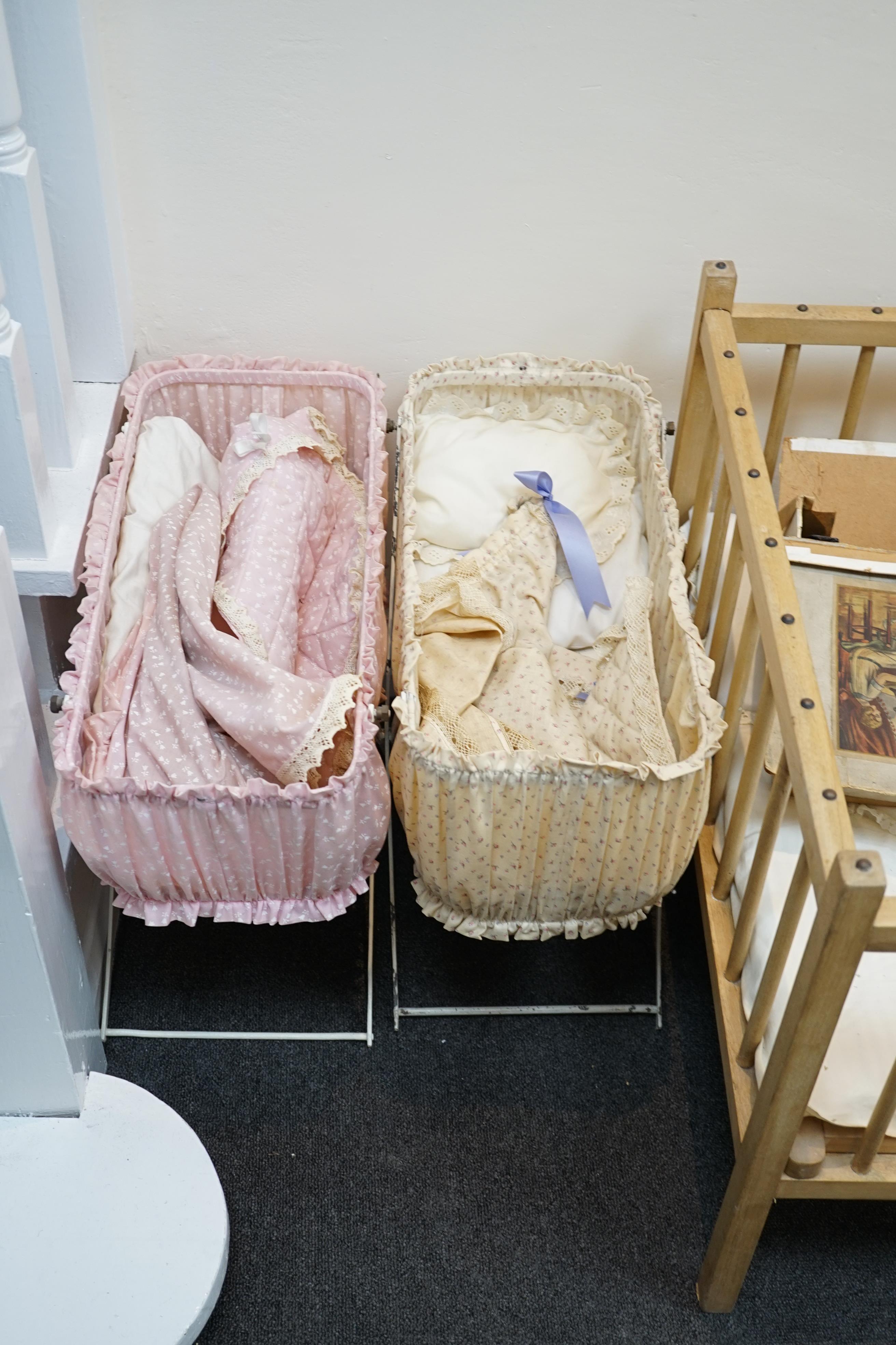 A collection of nine doll’s cribs of wood or wrought iron construction, together with two nineteenth century style doll’s ’bath chairs’, a toy mangle, Disney themed Snow White carpet sweeper and a boxed child’s sewing ma